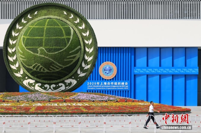 8月31日，天津，一名工作人員從2025年上海合作組織峰會主會場外的景觀花壇旁經(jīng)過。當(dāng)日，2025年上海合作組織峰會在天津舉行。<a target='_blank' href='/'><p  align=