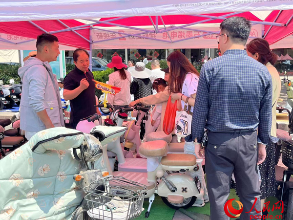 某電動自行車品牌工作人員向消費者介紹以舊換新相關情況。人民網記者 杜燕飛攝