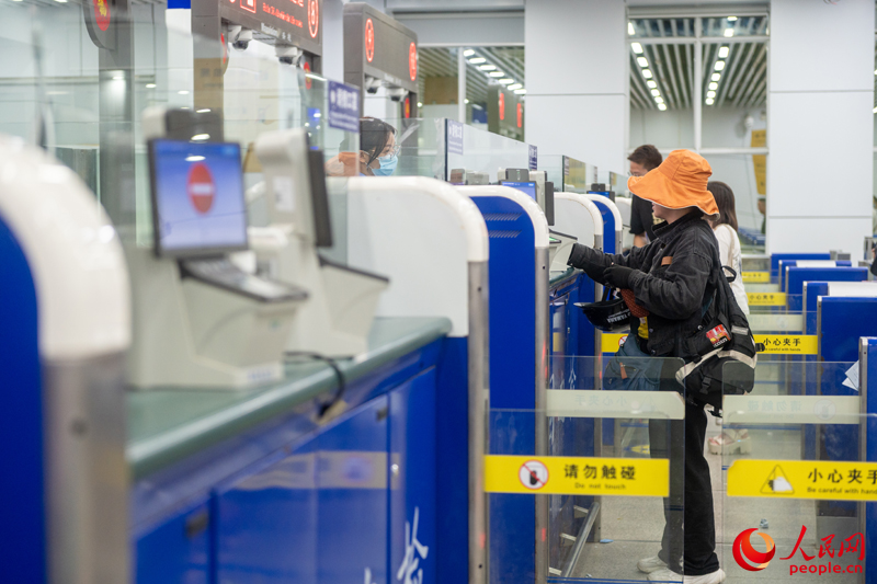 越南游客正在辦理入境手續(xù)。人民網(wǎng)記者 嚴(yán)立政攝