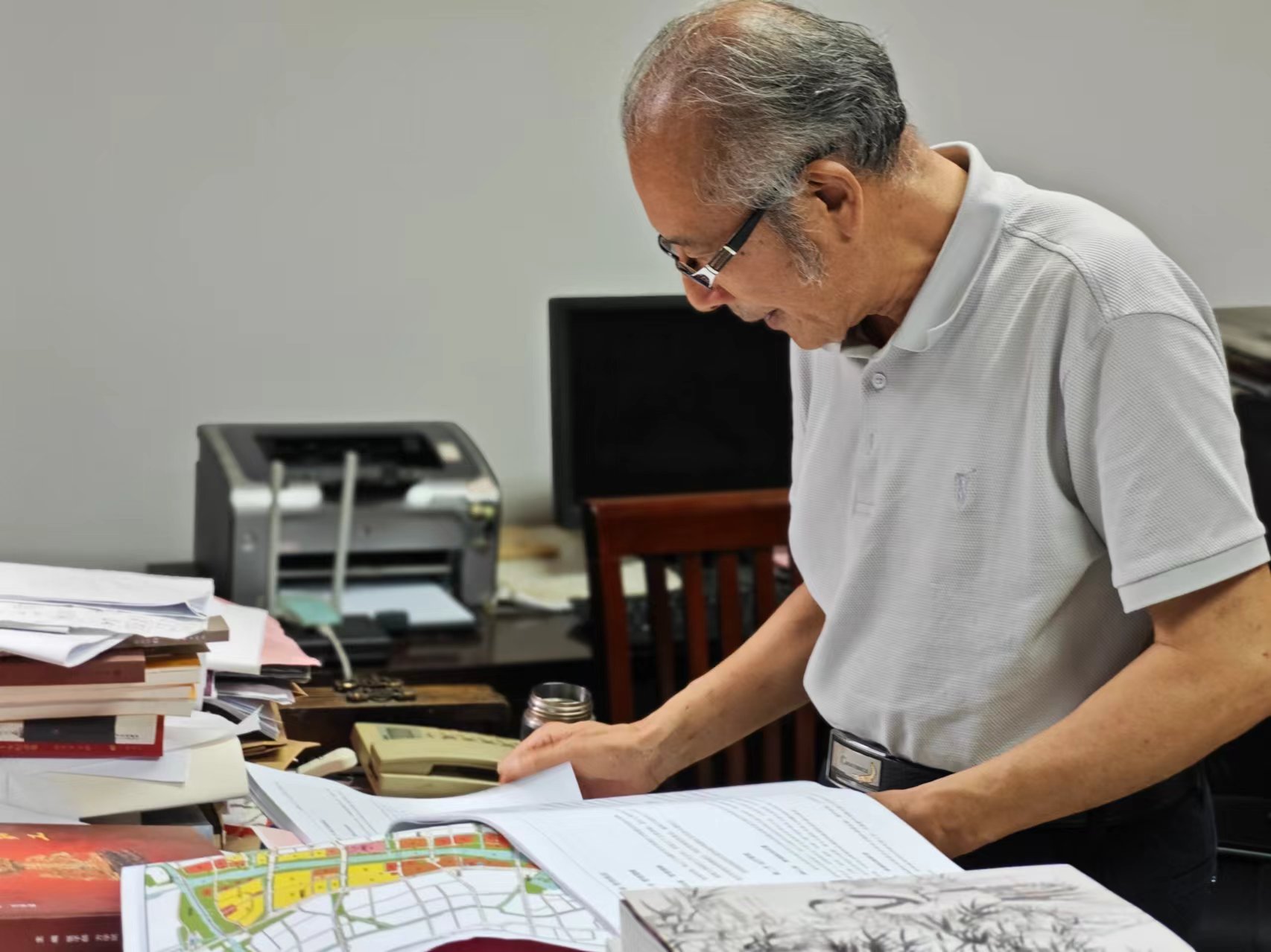 顧風(fēng)在辦公室翻閱資料。人民網(wǎng)記者 黃鈺攝