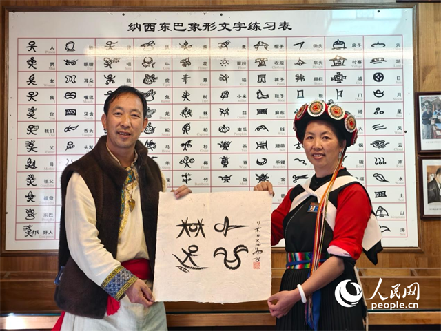 人民網(wǎng)“行進中國”云南調研采訪團走進麗江，和閏元現(xiàn)場用東巴文寫下“行進中國”。人民網(wǎng)記者 符皓攝