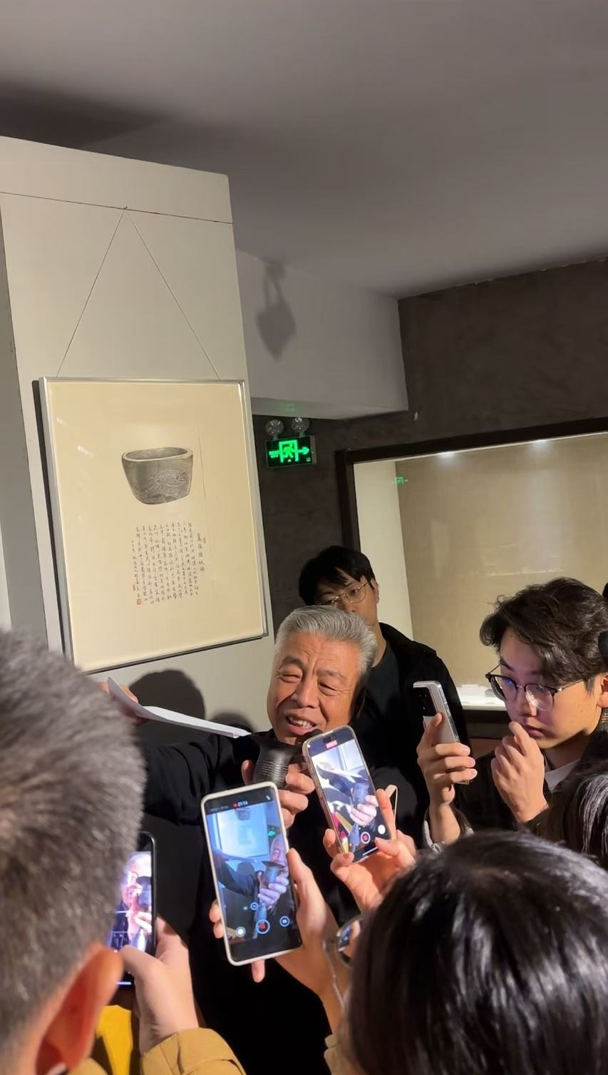 黑陶邢文化博物館館長邢葆東展示兩張相疊的A4紙，向記者解釋此為杯口的厚度。