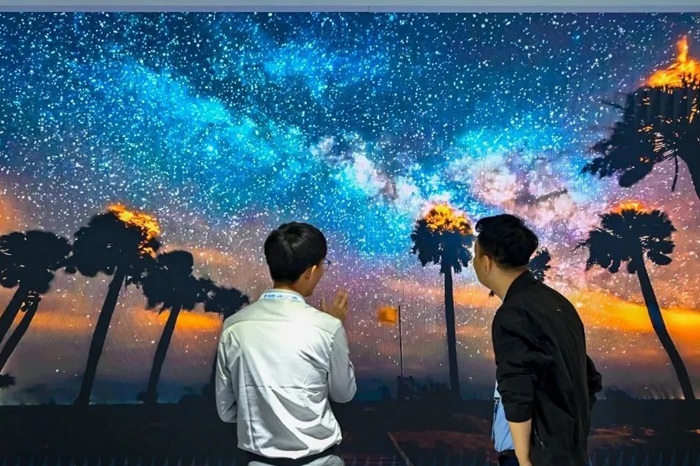 長春光博會希達(dá)電子展區(qū)，一位工作人員正在給一位觀眾講解。（長春新區(qū)供圖）