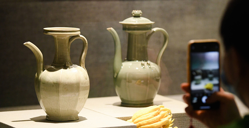 2021年9月14日，浙江省博物館，觀眾在拍攝北宋龍泉窯執(zhí)壺（左）和龍泉青瓷藝人劉杰制作的執(zhí)壺。