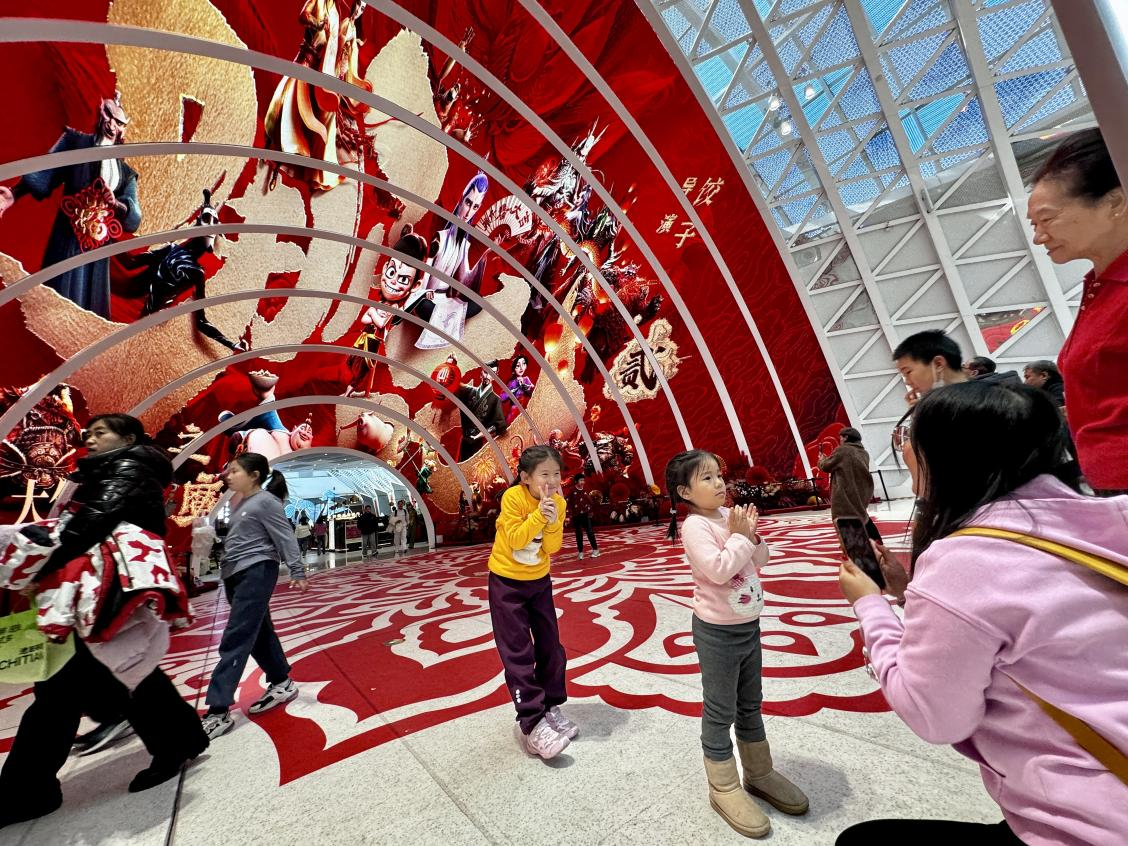 乙巳蛇年春節(jié)期間，影迷在《哪吒之魔童鬧?！肪薹?bào)前拍照打卡。