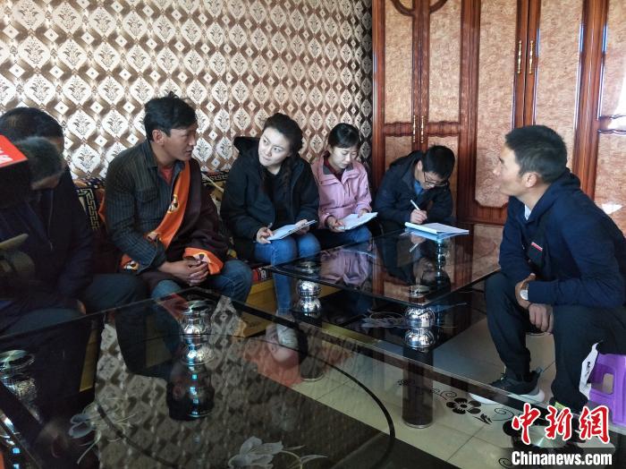 圖為調(diào)查組工作人員正在入戶調(diào)查?！∑钤鲚?攝