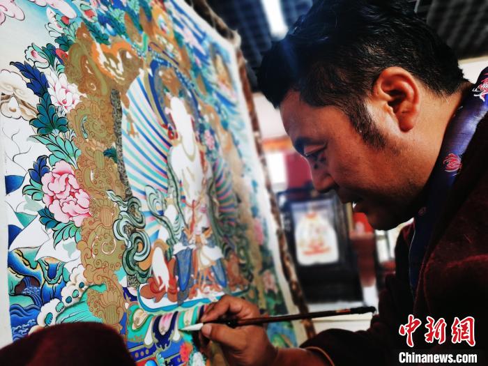 圖為久美尖措創(chuàng)作唐卡?！?zhí)砀?攝