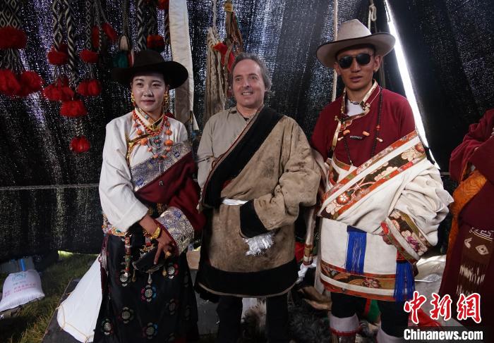 圖為一名外籍?dāng)z影師(中)身穿藏服和藏族民眾合影留念?！●R銘言 攝