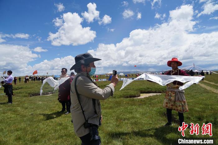 圖為一名外籍?dāng)z影師記錄當(dāng)?shù)夭刈鍤g迎儀式?！●R銘言 攝