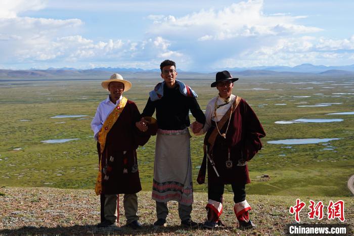 圖為一名留學(xué)生身穿自己國(guó)家的服飾和藏族民眾合影留念。　馬銘言 攝