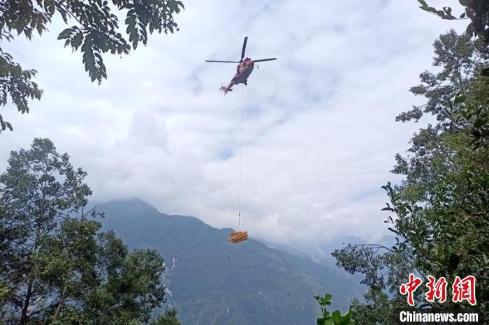 直升機起飛將搶修塔材運往海拔1950米的110千伏唐下線29號塔位?！⌒鞈c明 攝