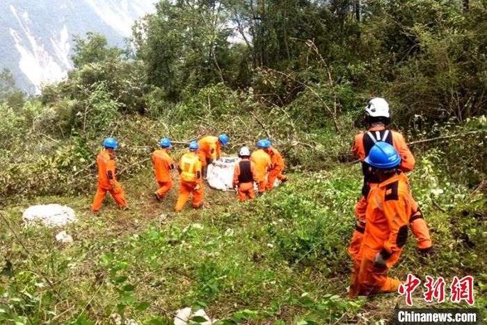 海拔1950米唐29號塔位搶險隊員正搬運直升機吊運上山的搶險材料?！⌒鞈c明 攝