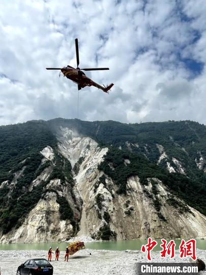 直升機正在運輸110千伏唐下線應急塔塔材。　衛(wèi)科 攝