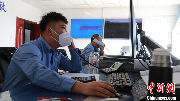 圖為貨運(yùn)調(diào)度人員與外勤工作人員聯(lián)系掌握車輛裝載情況?！±钌?攝