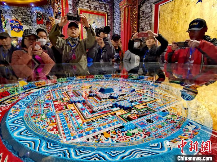 圖為參觀者拍攝壇城?！?zhí)砀?攝