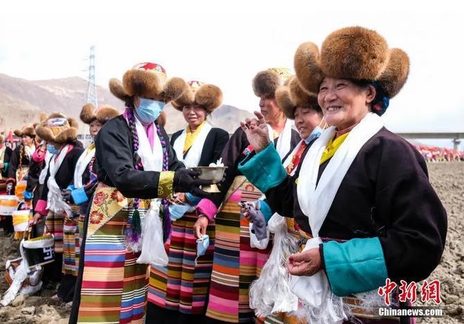 資料圖：西藏自治區(qū)拉薩市曲水縣才納鄉(xiāng)協(xié)榮村參加春耕儀式的村民互敬青稞酒。按照傳統(tǒng)，當?shù)卮迕裆碇?jié)日盛裝，舉行隆重的儀式，祈福一年的豐收。<a target='_blank' ><p  align=
