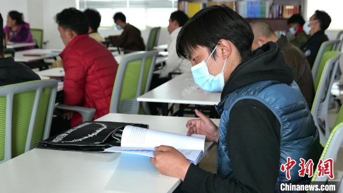 圖為正在閱讀“杰松達孜”藏歷法教材的學(xué)員?！≈x牧 攝