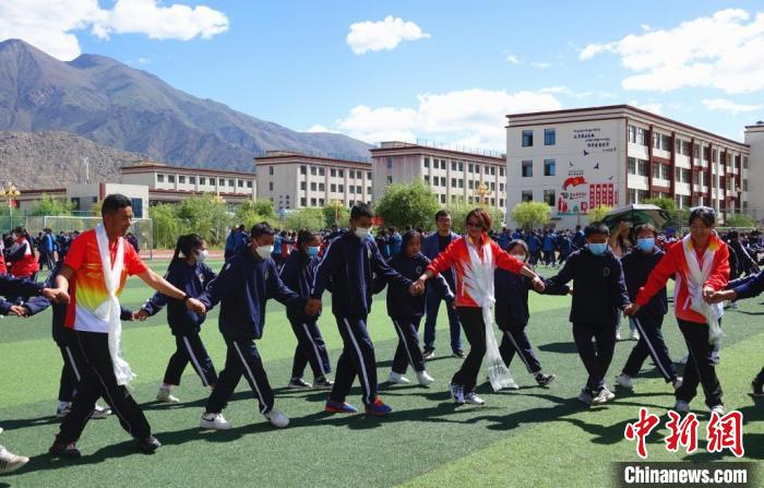 圖為世界冠軍與拉薩阿里地區(qū)高級(jí)中學(xué)學(xué)生一起跳鍋莊?！∪轿木?攝