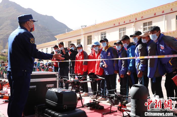 圖為消防指戰(zhàn)員為學(xué)生講解、演示先進救援裝備?！≮w琳 攝