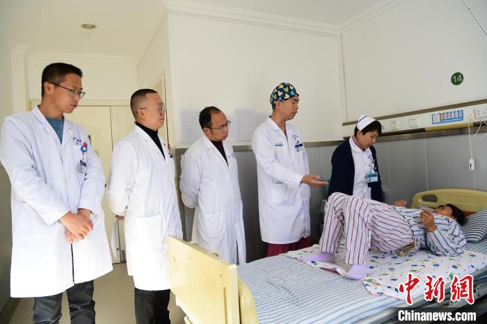 圖為何蔚副主任醫(yī)師(站右二)及團隊術(shù)后指導(dǎo)患者進行腰背肌鍛煉?！∝暩聛硭?攝