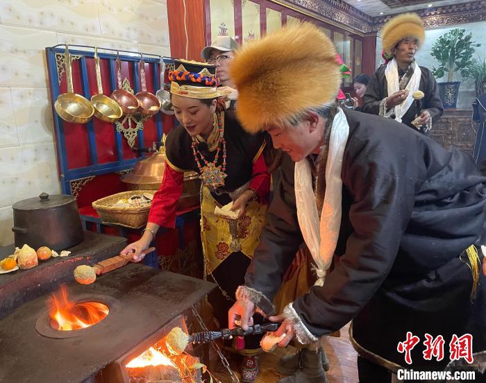 圖為人們?cè)诨鹕峡竟?jié)日美食“結(jié)達(dá)”?！∪轿木?攝