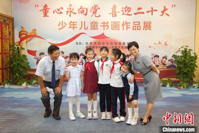 圖為與會嘉賓與入選畫作的“小作者”們在展覽上合影?！≈袊貙W研究中心供圖