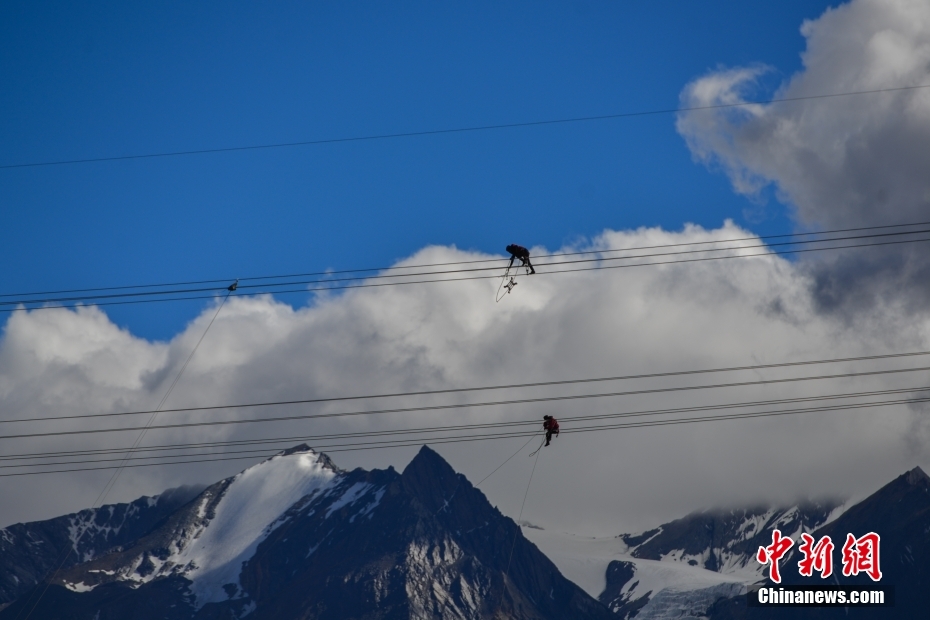 資料圖為2020年6月23日，西藏阿里聯(lián)網(wǎng)工程施工人員在日喀則希夏邦馬雪山附近進行走線作業(yè)，安裝絕緣設(shè)備。 <a target='_blank' href='/'><p  align=