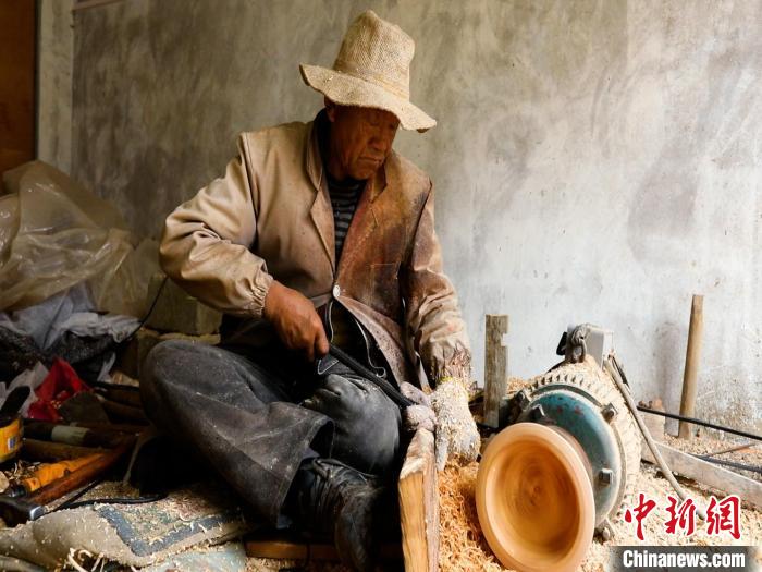 圖為手工藝人正在制作木碗?！?鄧海平 攝