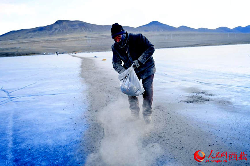 牧民在冰面上撒灰鋪成通道。人民網(wǎng) 李海霞攝