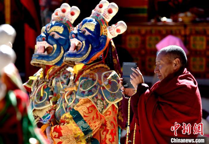 2月19日，正在拍攝跳神活動(dòng)的僧人。　李林 攝
