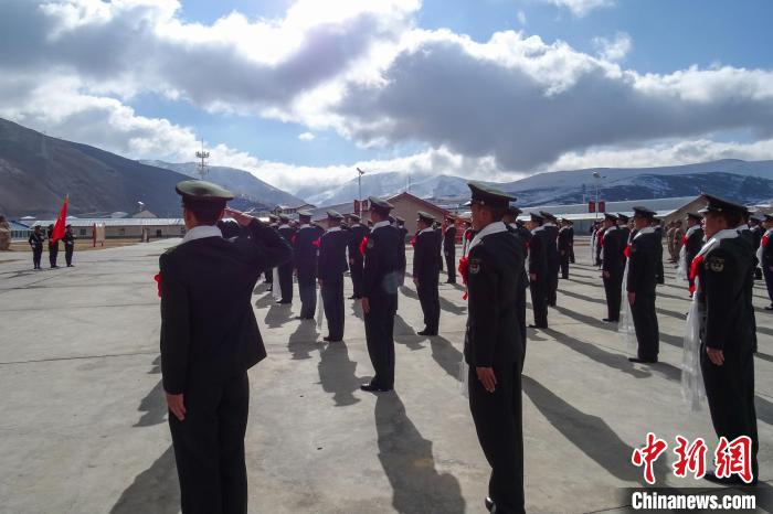 雪山下，退役士兵向軍旗敬軍禮。　李學(xué)文 攝