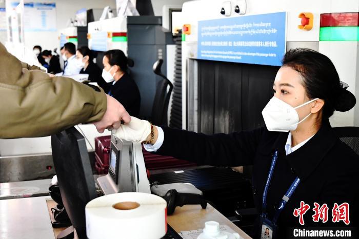 圖為機(jī)場工作人員為旅客辦理行李托運(yùn)。　周航 攝