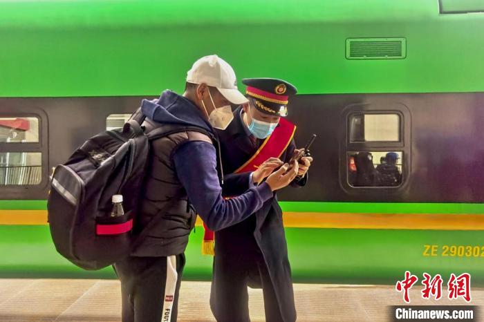 圖為日喀則火車(chē)站工作人員服務(wù)乘客?！《飞降?攝