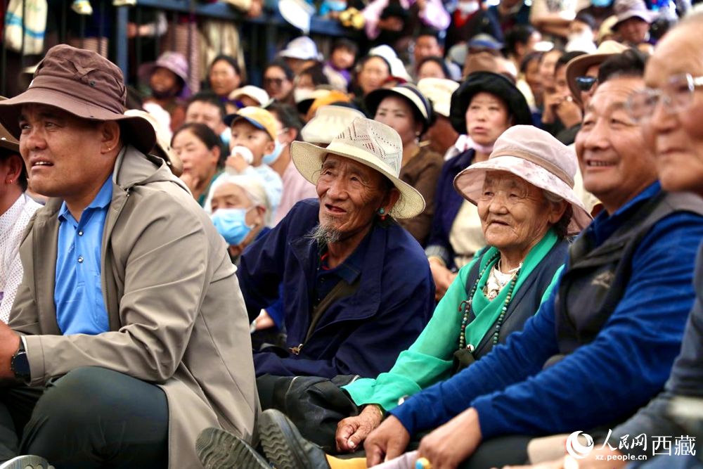 當(dāng)?shù)厝罕姾陀慰陀^看藏戲演出。