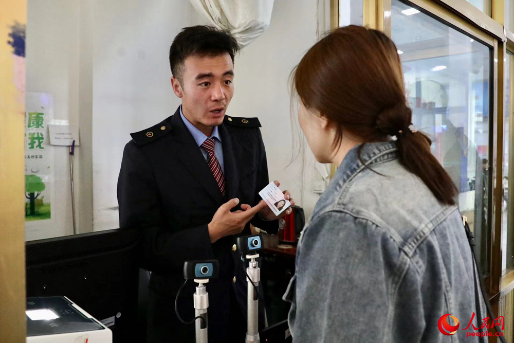 車站工作人員向旅客解答疑問。人民網(wǎng)記者 次仁羅布攝