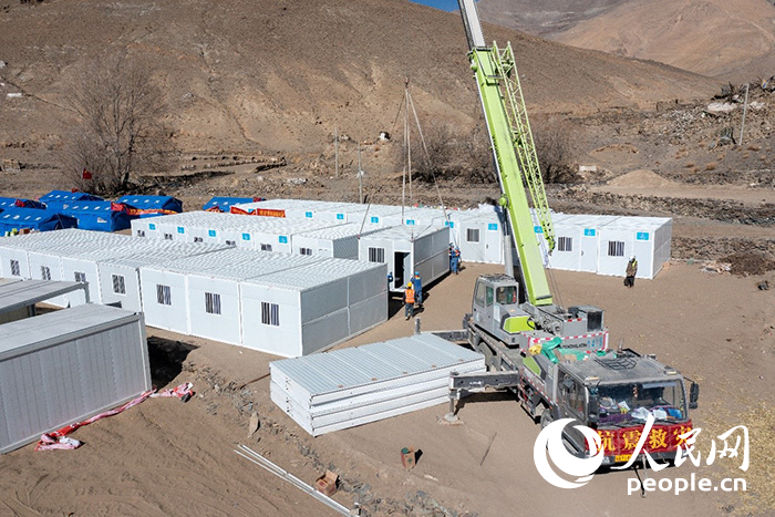 1月9日，在日喀則市定日縣長所鄉(xiāng)古榮村安置點，救援人員和施工人員合力抓緊搭建移動板房，確保受災(zāi)群眾溫暖過冬。人民網(wǎng)記者 翁奇羽攝