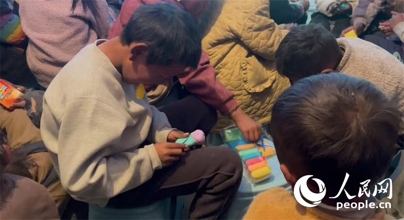 措果鄉(xiāng)塘仁村的孩子們正在用橡皮泥制作自己的情緒“小怪獸”。人民網(wǎng)記者 郝潔攝