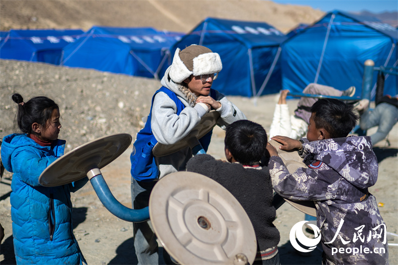 西藏星光社會工作服務中心社工久米旦增通過聊天談心，對孩子們進行災后心理疏導。人民網(wǎng)記者 翁奇羽攝