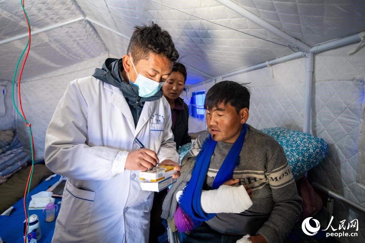 　醫(yī)生正在囑咐洛桑堅(jiān)參如何用藥。人民網(wǎng)記者 翁奇羽攝